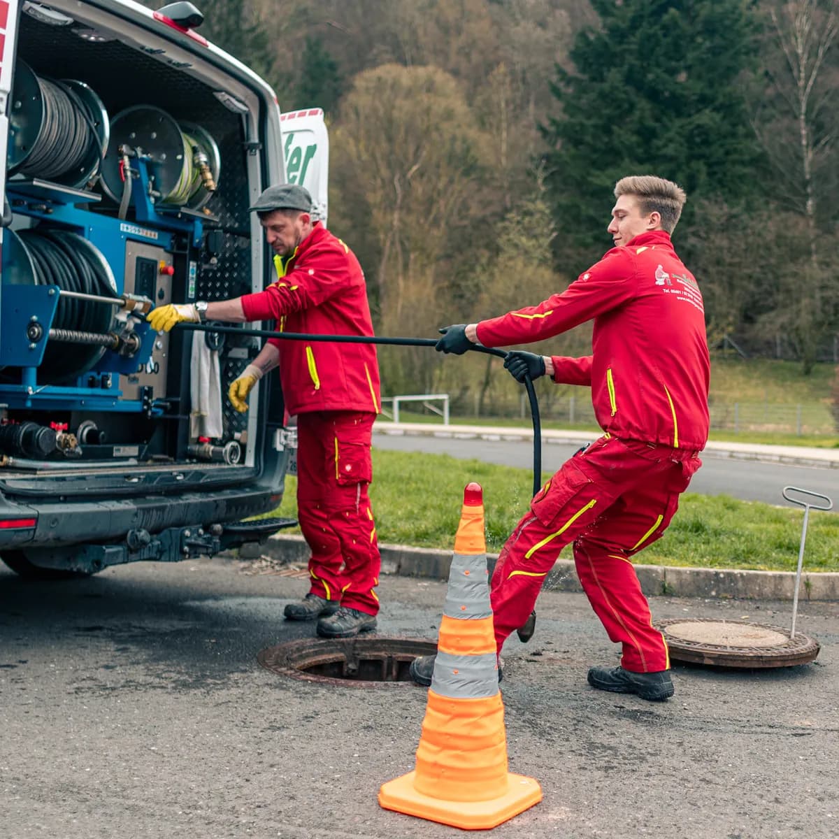Techniker von Hermann Schäfer Rohrreinigungsservice bei der Kanalarbeit am geöffneten Schacht